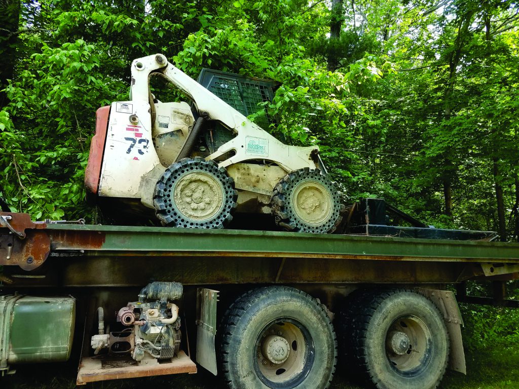 Skid steer loaded on QuickLoadz bed.